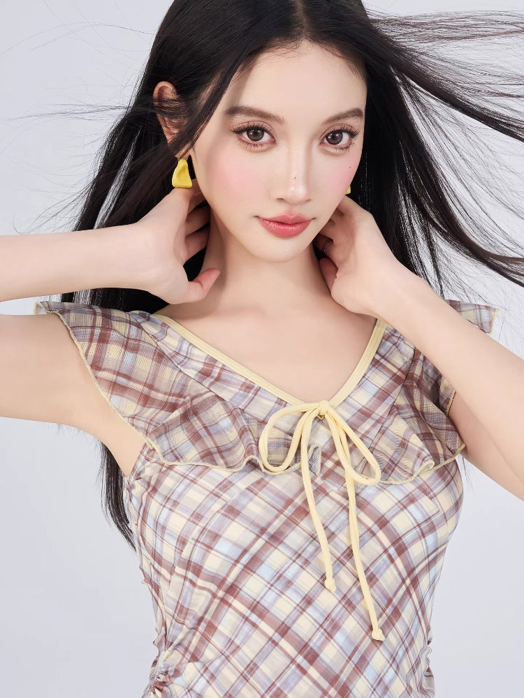 Close-up of the ruffled neckline and tie front detail on a plaid dress.