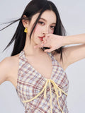 Close-up of the plaid halter dress neckline with yellow tie detail.