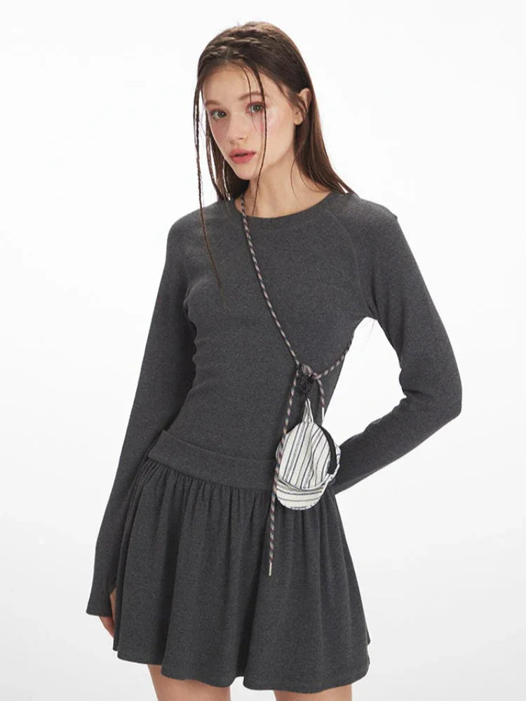 Front three-quarter view of a dark grey ribbed drop waist mini dress.
