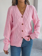 Woman wearing a pink cable knit cardigan with a v-neck and button front