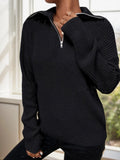 Close-up of a black knit half-zip sweater with a pointed collar.