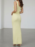 rear view of a woman wearing a pale yellow sleeveless maxi dress with a scoop neck and textured knit pattern