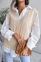 Close-up of a woman wearing a beige cable knit V-neck sleeveless sweater vest over a white collared shirt.