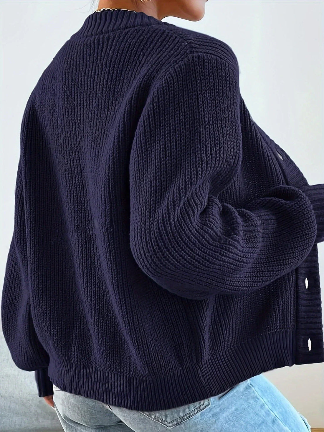 dark blue knit cardigan worn from the back