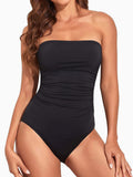 Woman in a black strapless one-piece swimsuit with ruched sides