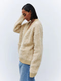 Side view of a woman in a fluffy faux fur cardigan.