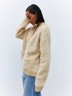 Side view of a woman in a fluffy faux fur cardigan.
