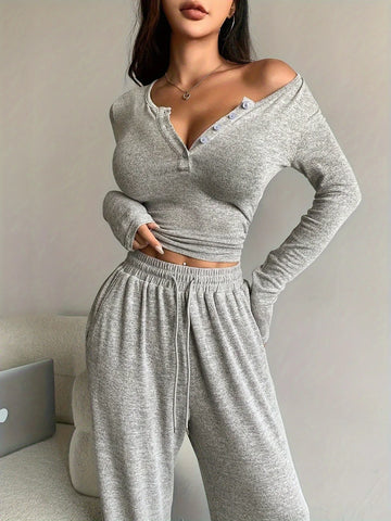 Woman wearing a grey heathered knit loungewear set with a button-up Henley top and wide-leg pants.