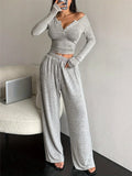 Woman posing in a grey heathered knit loungewear set, showing the side view.