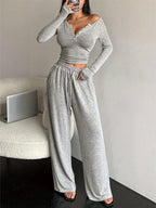 Woman posing in a grey heathered knit loungewear set, showing the side view.