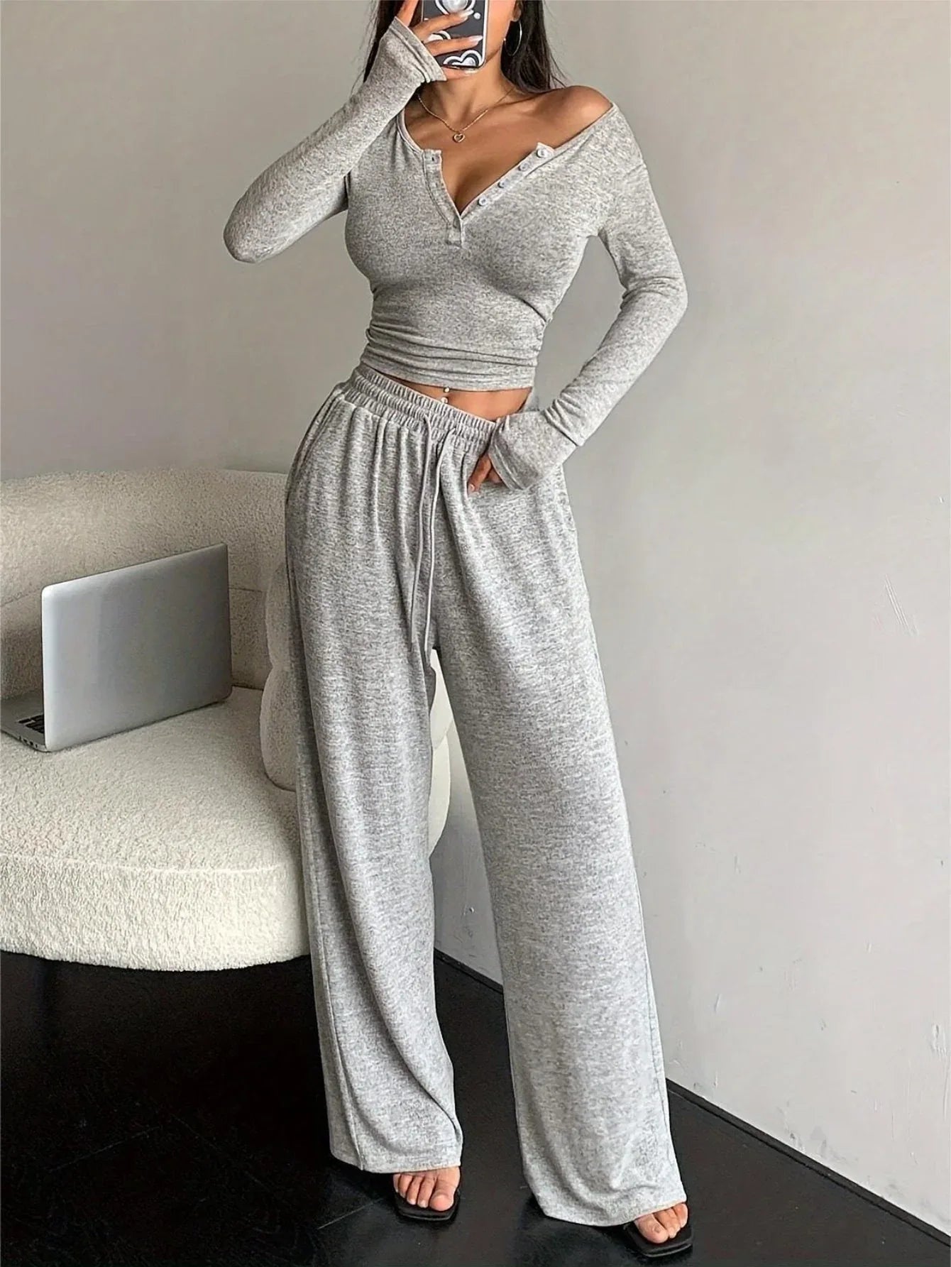 Woman posing in a grey heathered knit loungewear set, showing the side view.