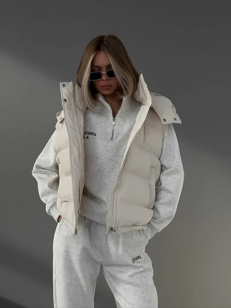 Woman wearing a cream puffer vest over a grey quarter-zip sweatshirt and sweatpants. Main image