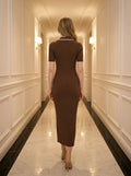 Back view of a woman wearing a brown ribbed knit midi dress with white collar trim, walking in a hallway.