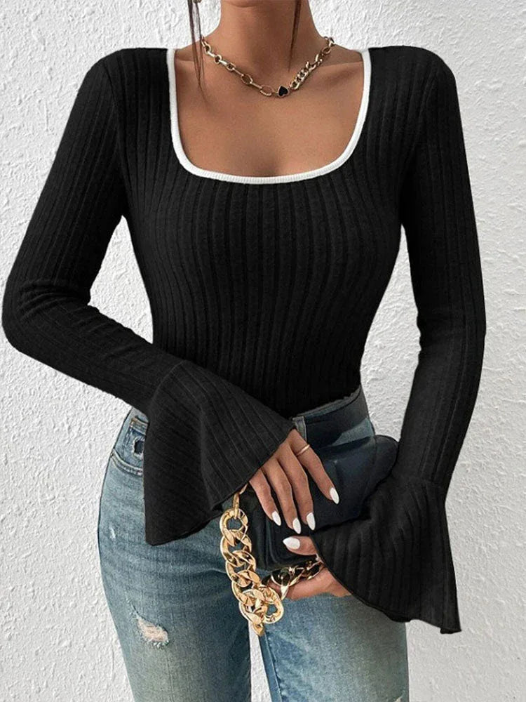Front view of a woman styled in a black ribbed knit top with a square neckline and bell sleeves.