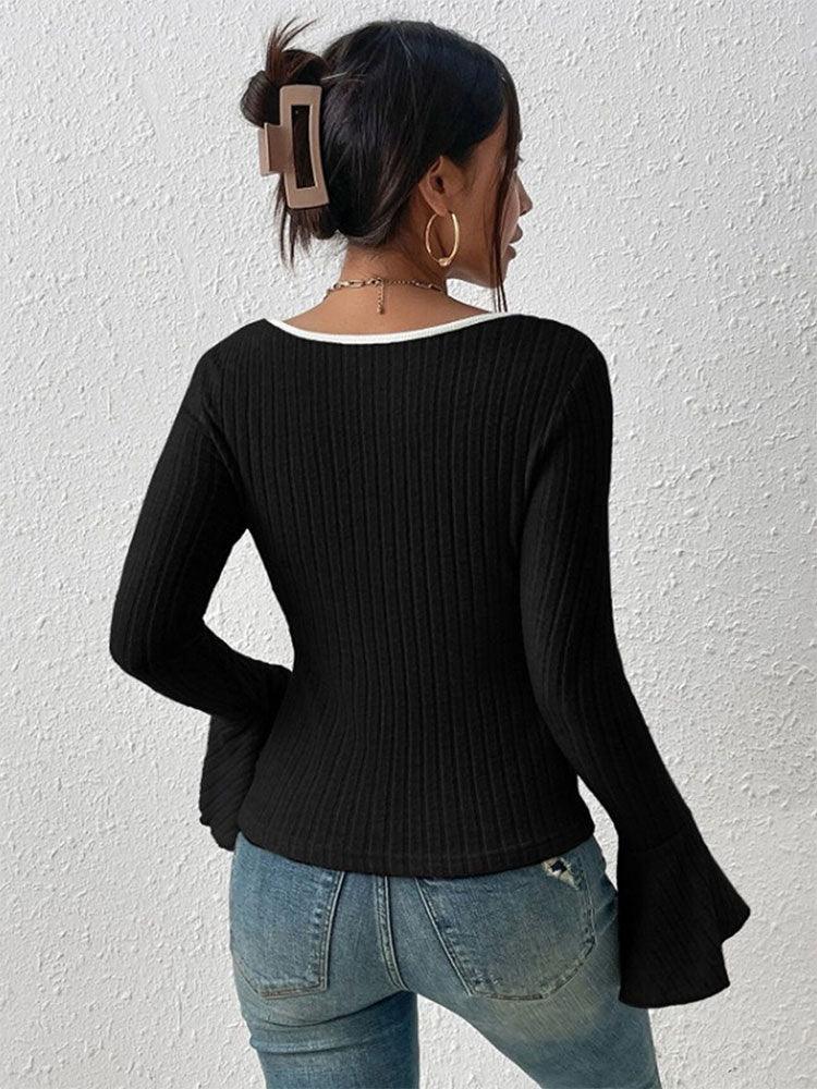 Back view of a woman in a fitted black ribbed knit top with contrast neckline trim.