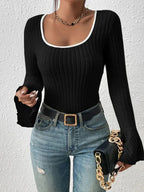 Close-up of a black long-sleeve top with ribbed texture and flared cuffs.