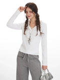 Close-up of woman wearing white long-sleeve top and grey wide-leg fleece pants