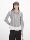 Front view of a woman wearing a long-sleeved plaid button-down shirt with a white lace ruffled hem, black wide-leg pants, and glasses.
