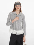 Close-up front view of a woman wearing a long-sleeved collared blouse with a plaid pattern and white lace trim at the hem, showing the button detail.