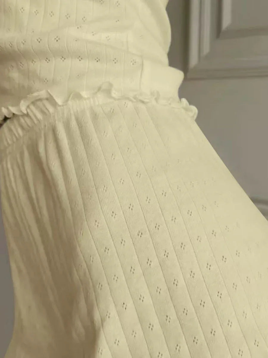 Close-up of the textured knit fabric and ruffled hem on off-white shorts
