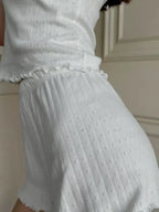 Detail of the ribbed texture and ruffled waistband on white shorts
