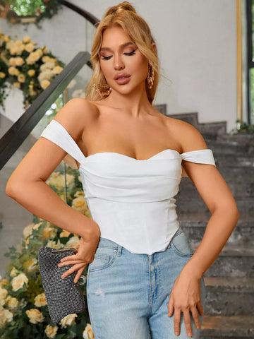 Woman wearing a white off-the-shoulder ruched crepe top with a sweetheart neckline and light wash jeans.