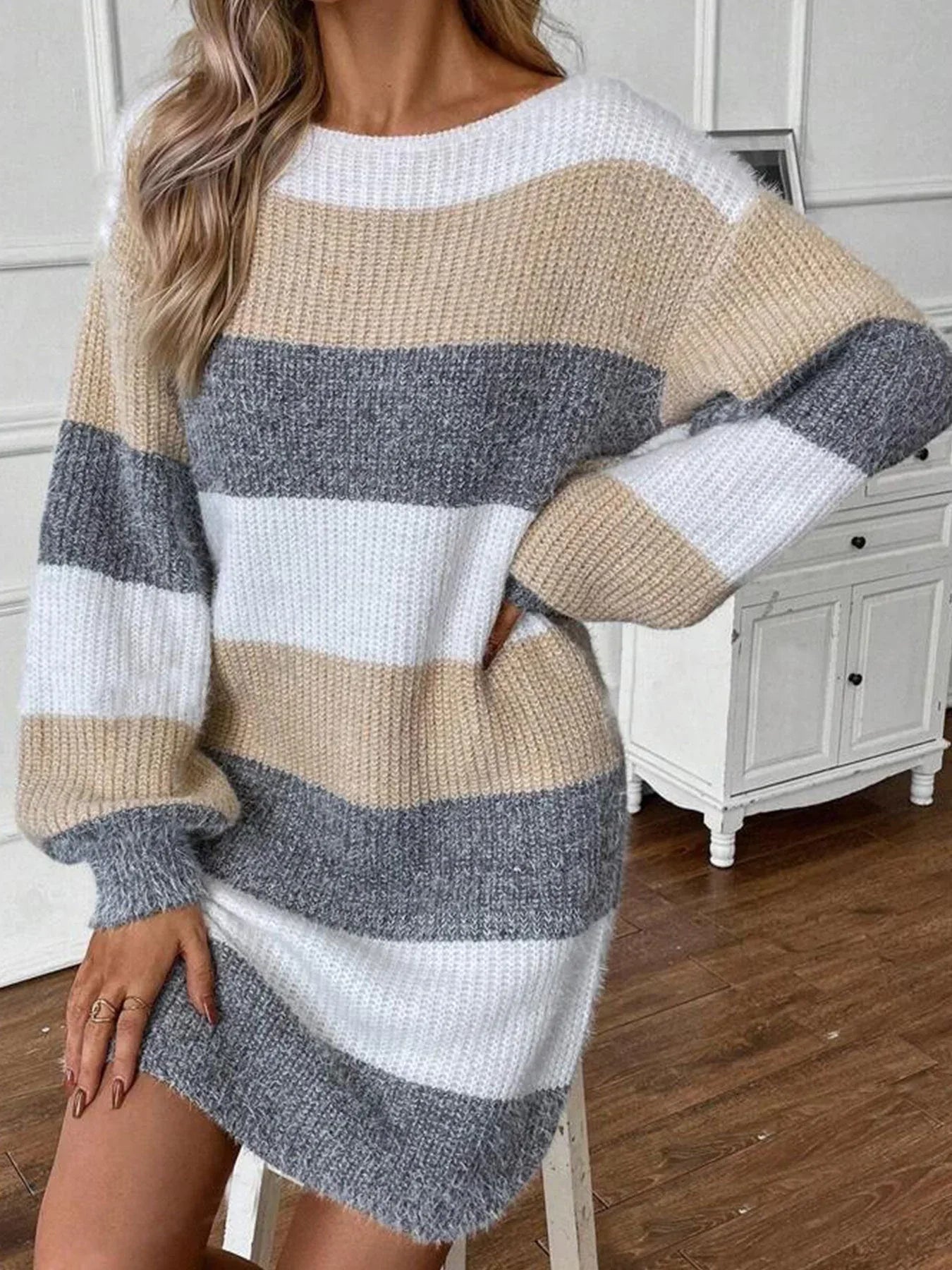 Woman posing in a long-sleeved striped sweater dress.