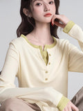 Close-up of a cream long-sleeve henley shirt with lime green contrast trim and buttons.