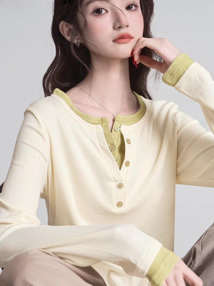 Close-up of a cream long-sleeve henley shirt with lime green contrast trim and buttons.