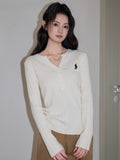 Full body shot of a woman in a cream cable knit sweater and brown pants.