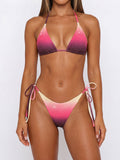 Woman wearing a gradient purple, pink, and cream rhinestone bikini with tie sides.