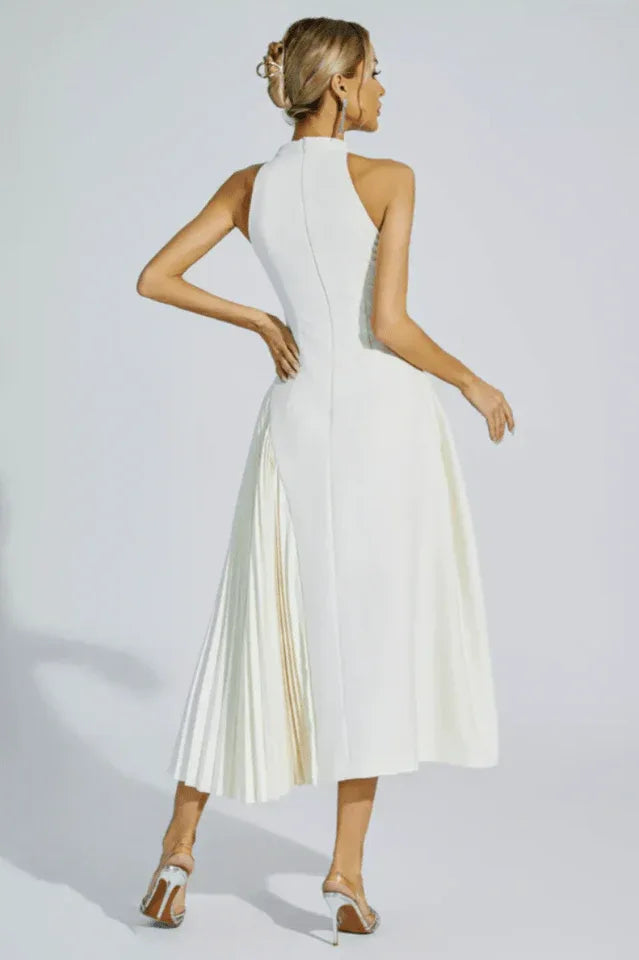 Woman holding a clutch bag with a white pleated midi dress