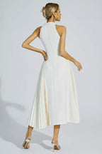 Woman holding a clutch bag with a white pleated midi dress
