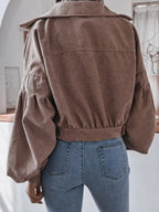 Back view of a woman in a brown corduroy jacket, showcasing the voluminous sleeves and cropped hem.