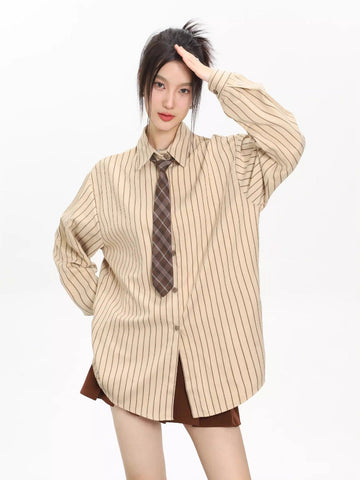 Woman wearing an oversized beige pinstripe button-down shirt with a brown plaid tie and a brown skirt.