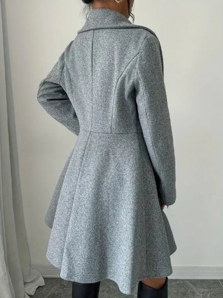 Back view of a woman wearing a grey wool blend tweed coat with a flared hem.