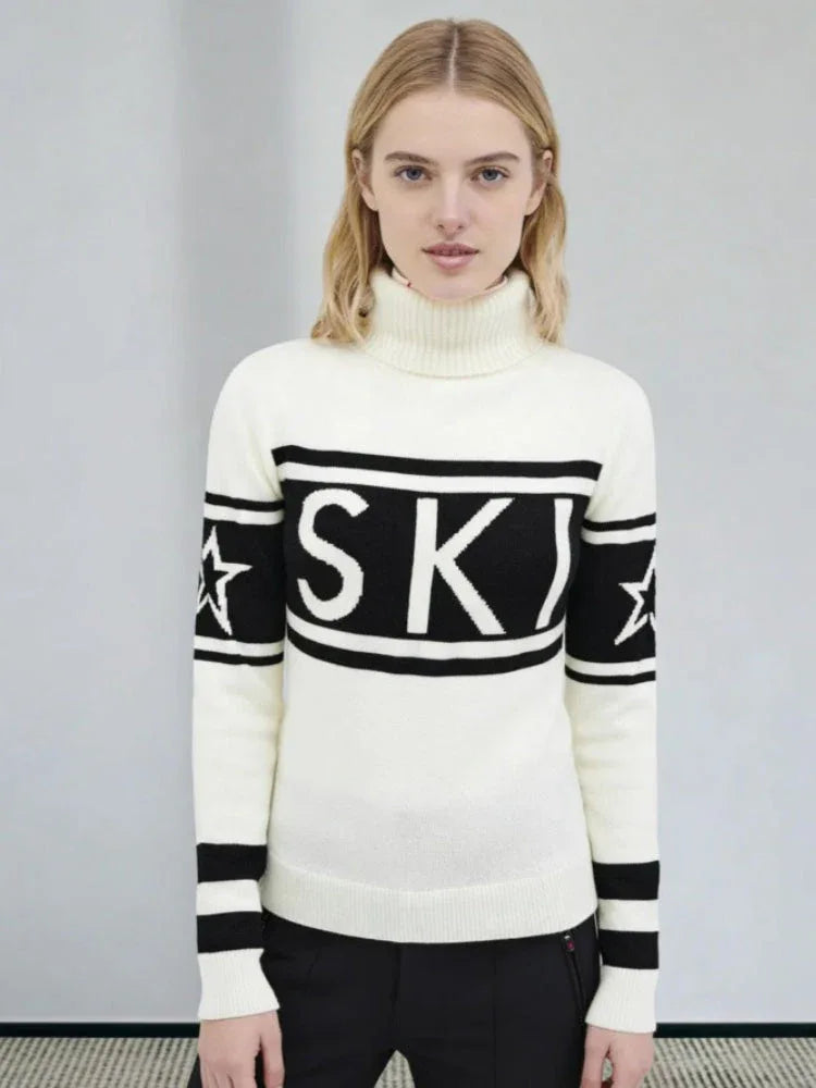 Woman wearing a cream and black knit turtleneck sweater with 'SKI' graphic and striped sleeves