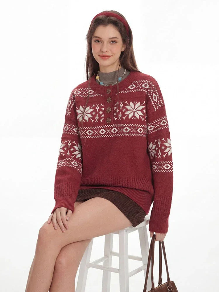 Woman sitting on a stool wearing a red knit sweater with a white Fair Isle pattern and a button placket.