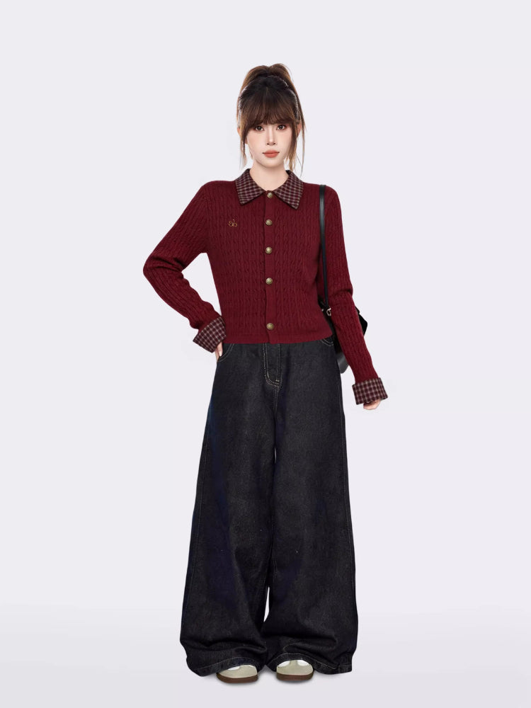 Full body shot of a woman in a burgundy cable knit cardigan and wide-leg jeans, standing against a white background.