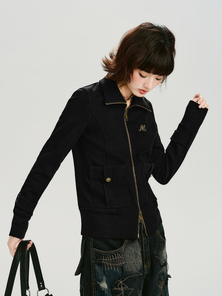 Close-up of the black knit jacket showing the ribbed turtleneck and zip detail.