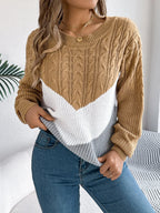 Woman showing the front detail of a tan, white, and grey chevron color block knit sweater