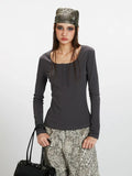 Close-up front view of a woman wearing a dark grey long-sleeve ribbed knit top with a square neckline and buttoned placket, showcasing the fabric texture.