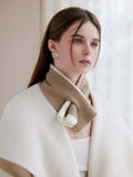 A woman models a soft knit scarf with a contrasting color block pattern