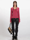 Woman wearing a rose red long sleeve scoop neck top