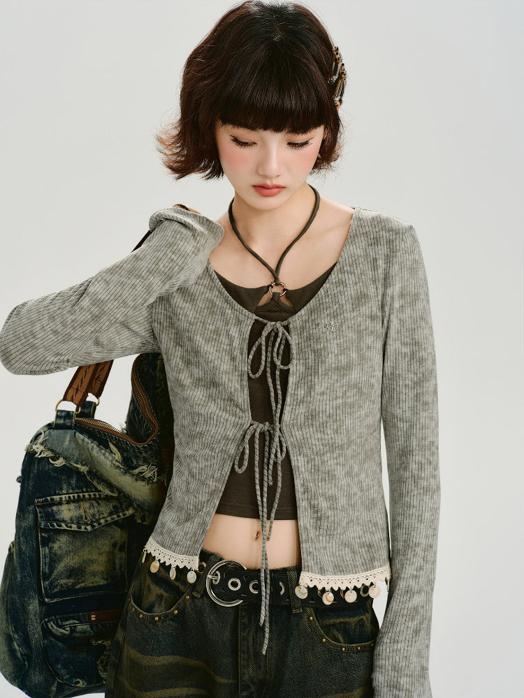 Woman wearing a grey ribbed knit tie-front cardigan with lace trim