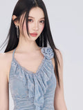 Close-up of the light blue textured lace halter dress showcasing ruffle detailing and floral applique