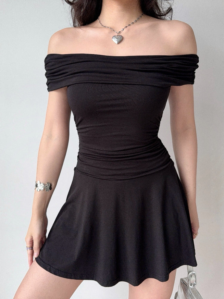 Woman wearing a black off-the-shoulder jersey knit dress with a ruched bodice and flared skirt