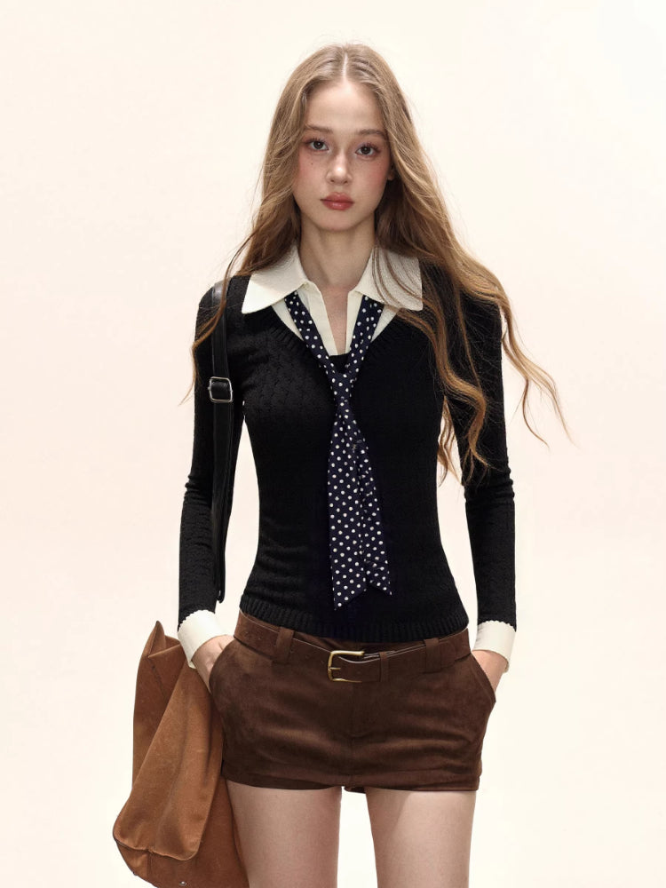 Woman wearing a black cable knit collared sweater with a white collar and cuffs, paired with brown shorts and a polka dot scarf.