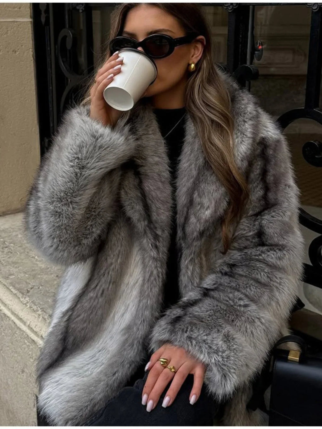 Woman wearing a grey faux fur coat and black pants