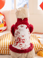 Rear view of a cat wearing a red and white traditional Chinese inspired pet vest with faux fur trim and floral embroidery.
